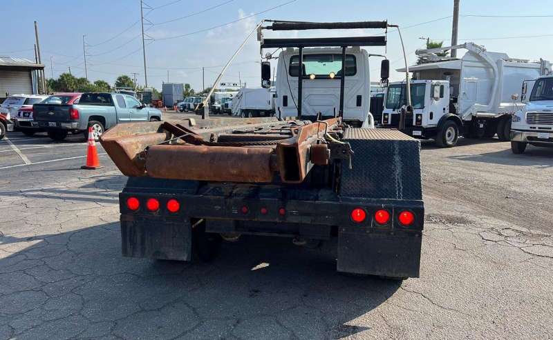 A rear view of a used roll off truck for sale at Dirt Cheap Truck Sales.
