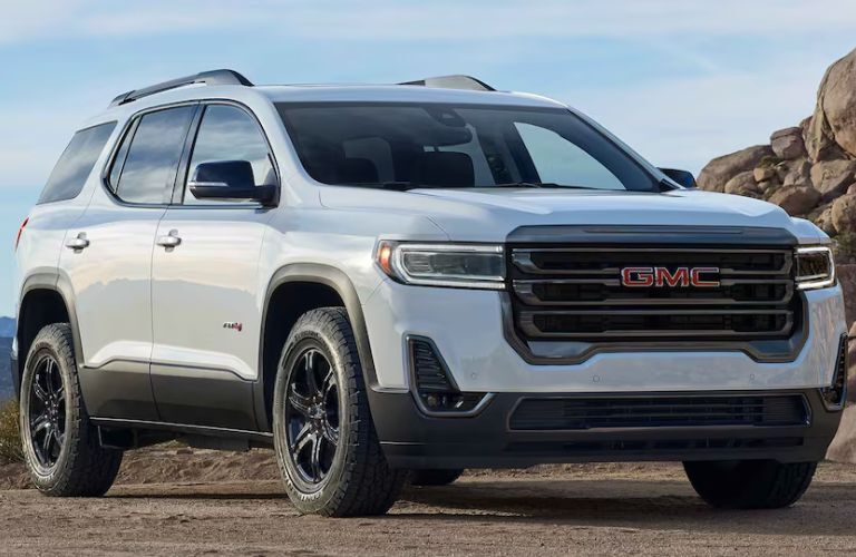 A 2023 GMC Acadia on a sandy terrain