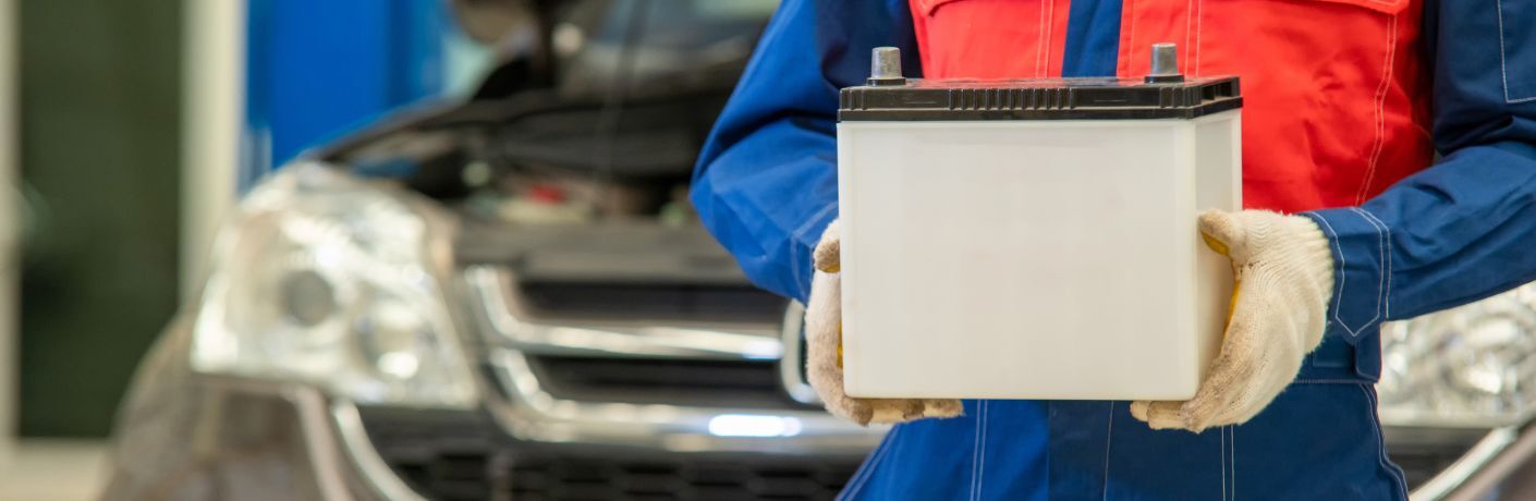 Technician taking a car battery for testing