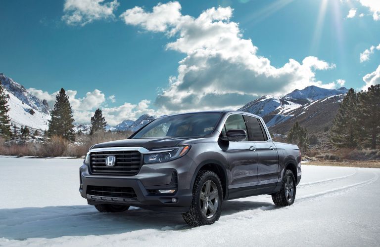 One grey color 2023 Honda Ridgeline is parked on the snow.