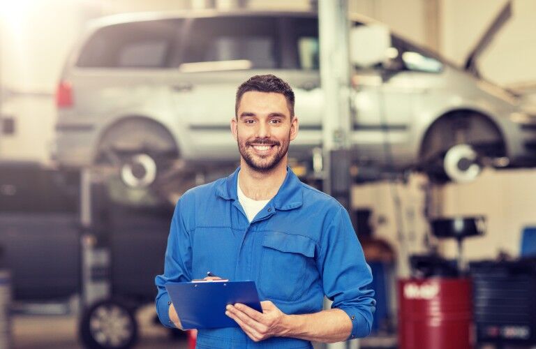 Smiling mechanic in a automotive service department
