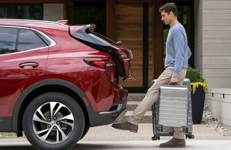 a man opening the hood of a 2022 Buick