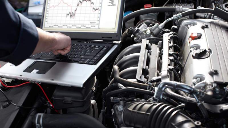A man running an engine diagnostic on a Mercedes