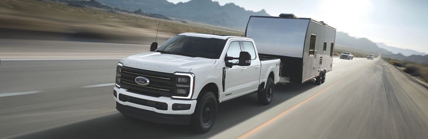 2025 Ford F-250 Super Duty in white towing a trailer