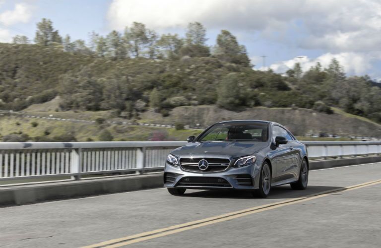 2019 MB CLS exterior front fascia and driver side on bridge with trees and hill in distance