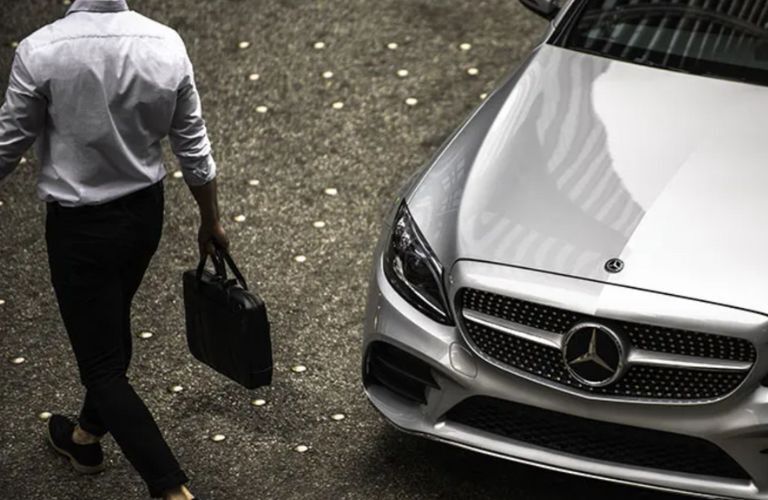 a man walking away from a Mercedes-Benz