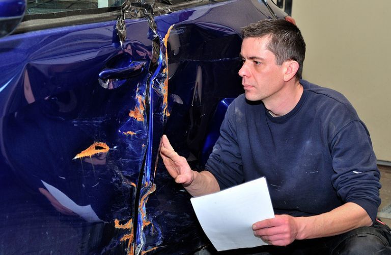 A mechanic inspecting a car
