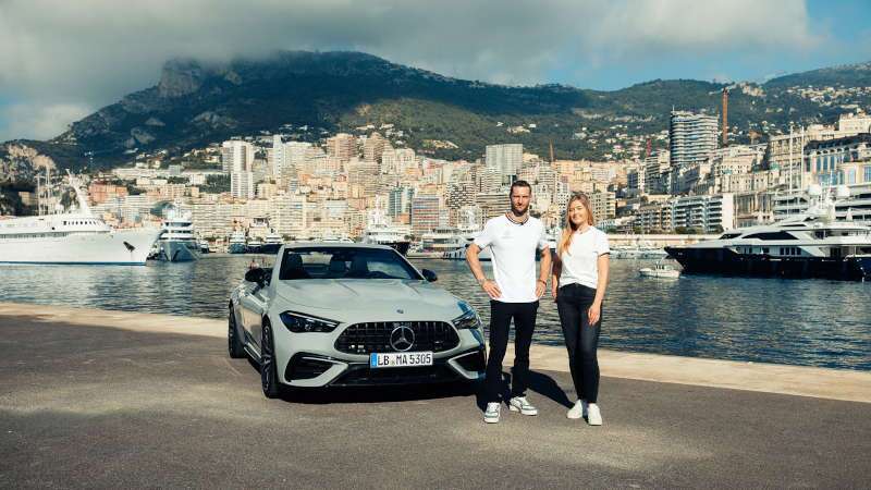 A couple enjoying their AMG® vehicle at a European yacht harbor