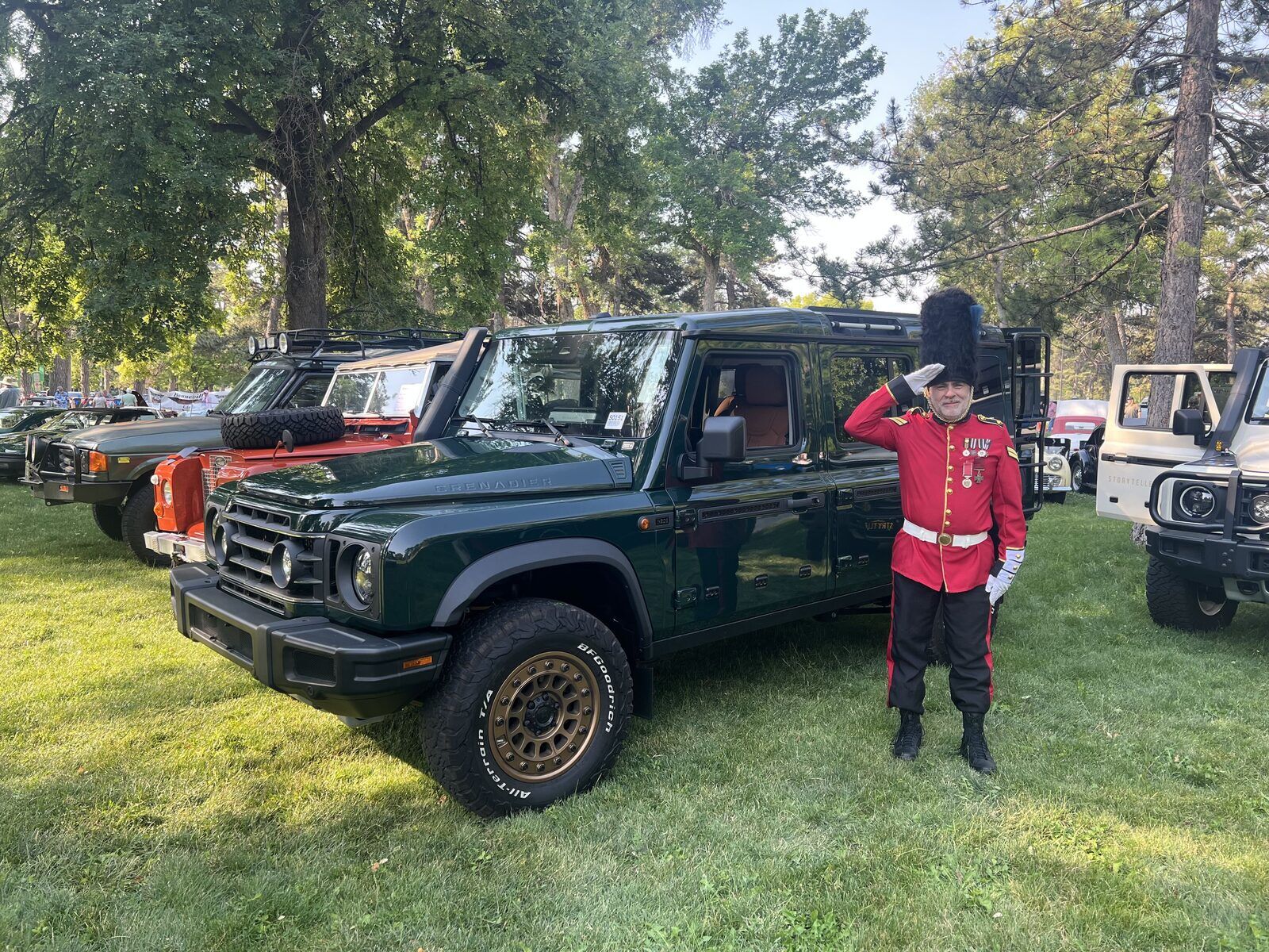 Warner team member in Grenadier Guard uniform saluting beside an INEOS Grenadier at British Field Day 2026