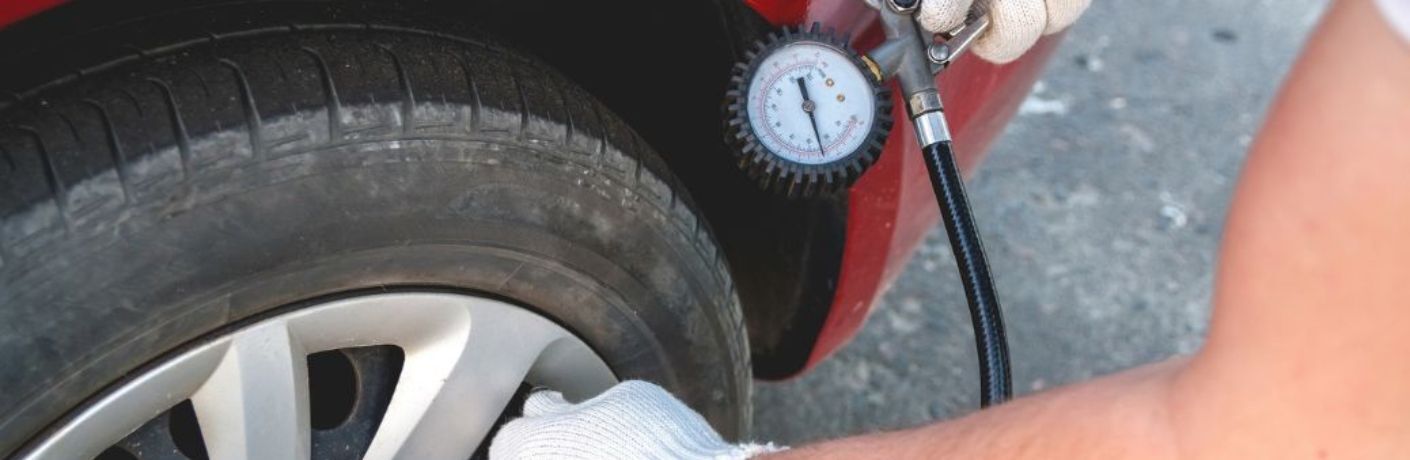 technician checking air pressure in a tire