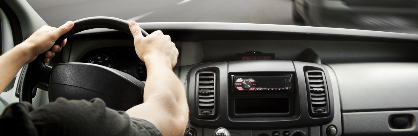 Representative image of a man's hands on a steering wheel