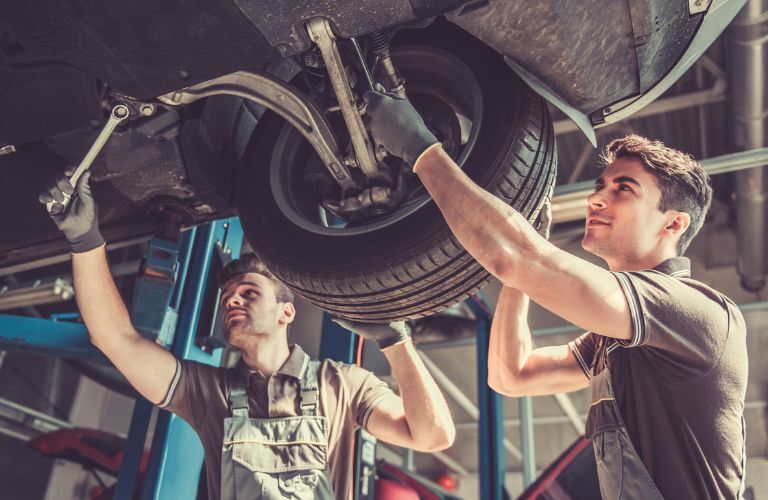 Technicians inspecting under the vehicle