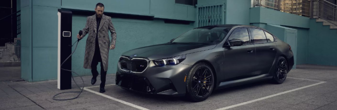 Man charging the 2025 BMW M5 Sedan
