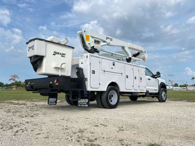 A rear quarter exterior view of a bucket truck using its extendable arm