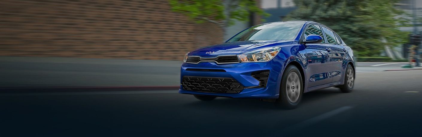 One blue color 2023 Kia Rio is running on the road.