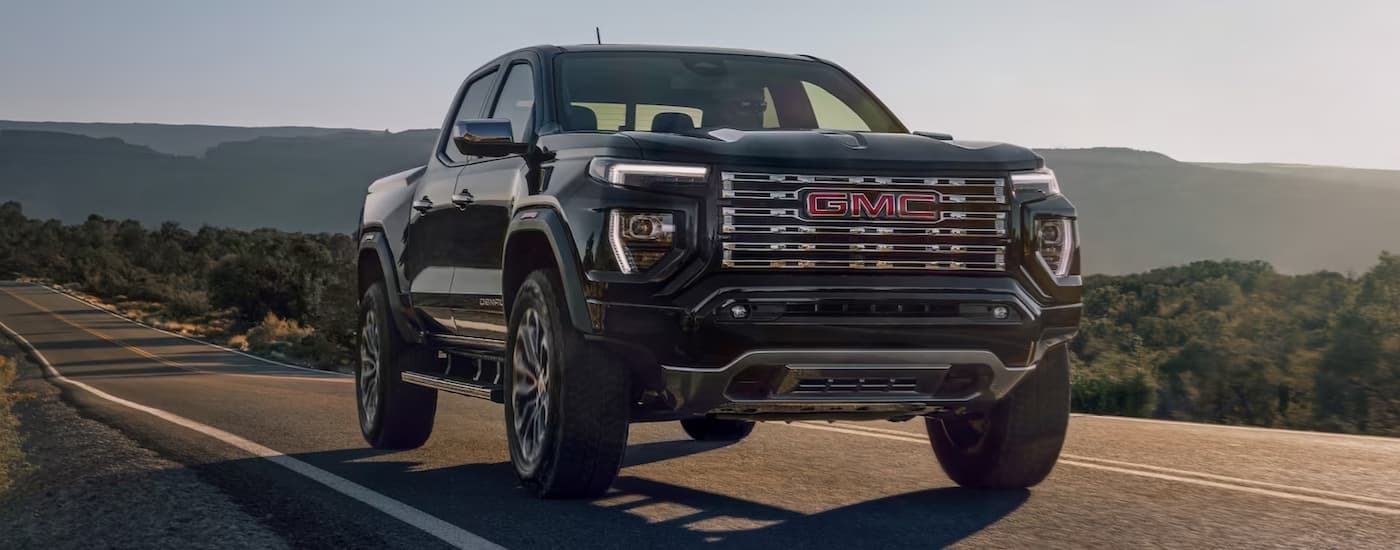 Black 2023 GMC Canyon driving on an open highway