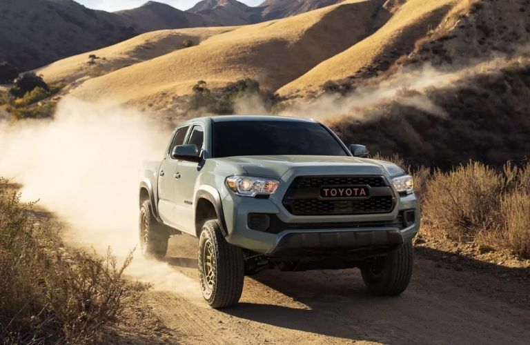 A 2024 Toyota Tacoma speeding on a gritty terrain