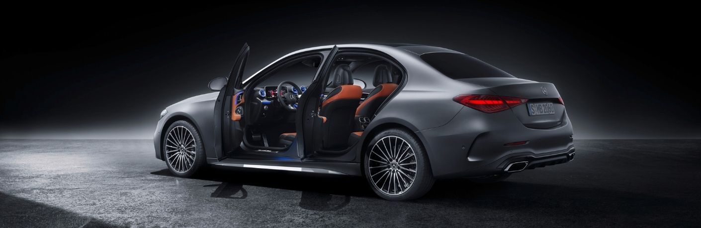 2022 MB C-Class exterior rear fascia driver side doors open with dramatic lighting