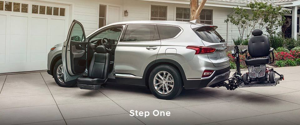 Car with mobility seat in front and towing a wheelchair rack