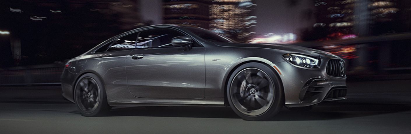 Front three-quarter view of the 2023 Mercedes-AMG E 53 Coupe driving on a city road