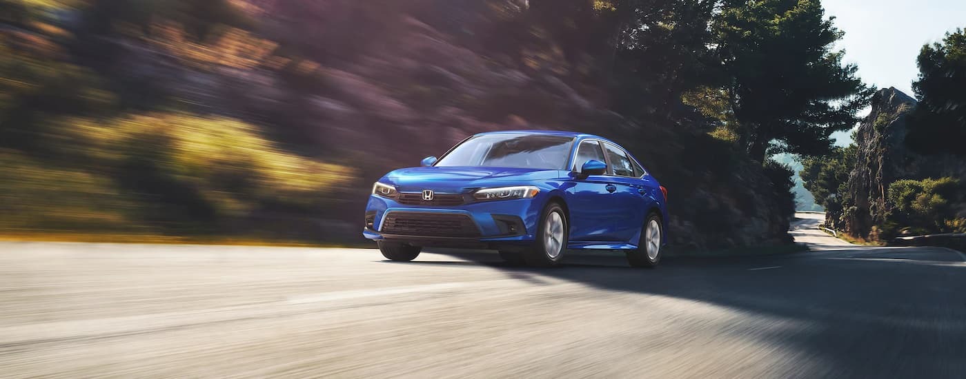 A blue 2022 Honda Civic LX driving on an open road.