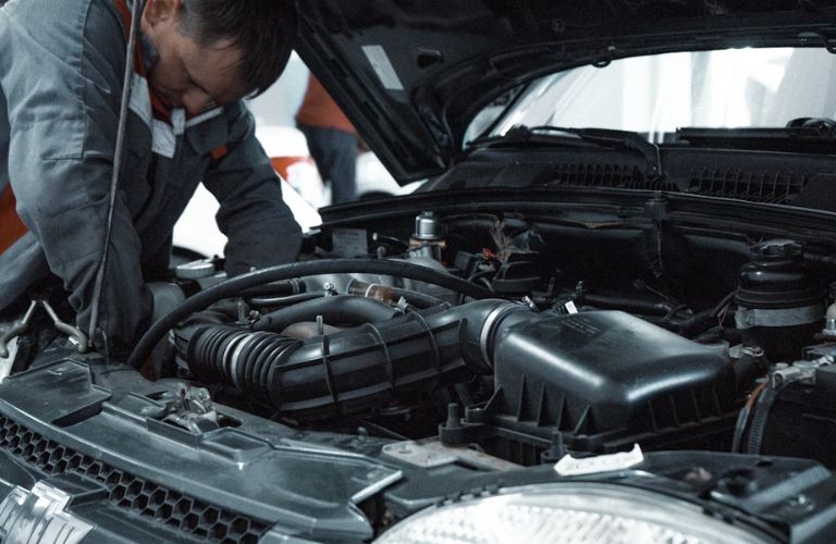 Technician checking under the hood of the vehicle