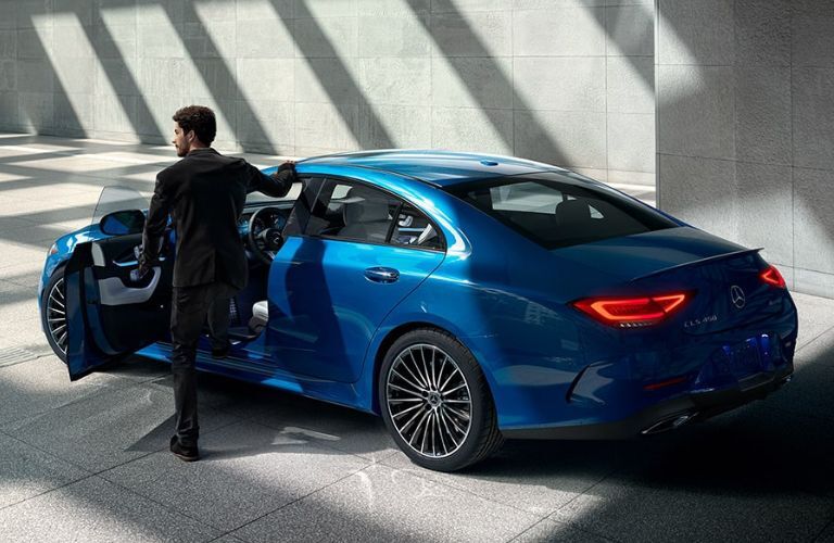 Rear three-quarter view of a man entering the 2023 Mercedes-Benz CLS 450 Coupe