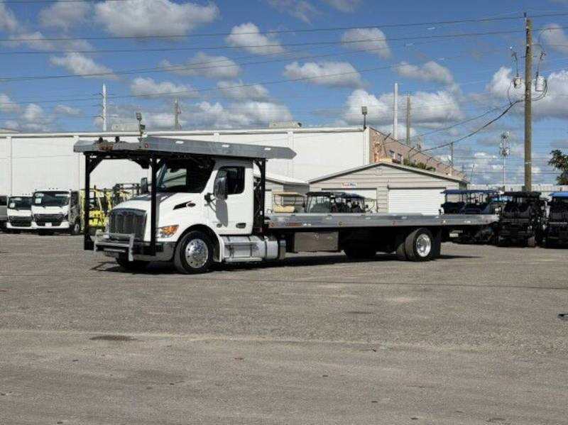 A front quarter exterior view of a Peterbilt car carrier truck with equipped with a Paccar diesel engine