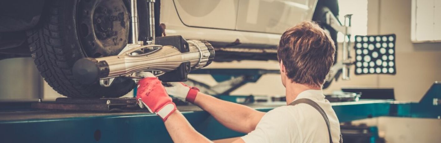 Technician checking the front-end alignment of a vehicle