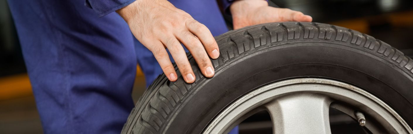 Car Mechanic checking a tire