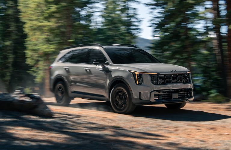 2025 Kia Sorento front and side angle in a forest