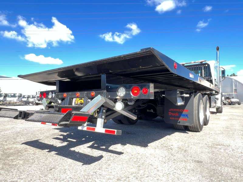 A rear quarter exterior view of a large flatbed tow truck