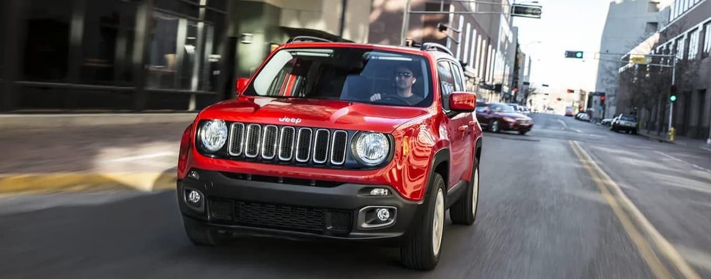 Red 2018 Jeep Renegade driving on a city street