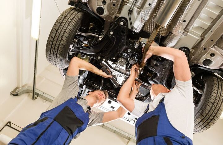 Two technicians working on a vehicle