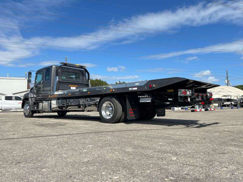 A side exterior view of a flatbed tow truck