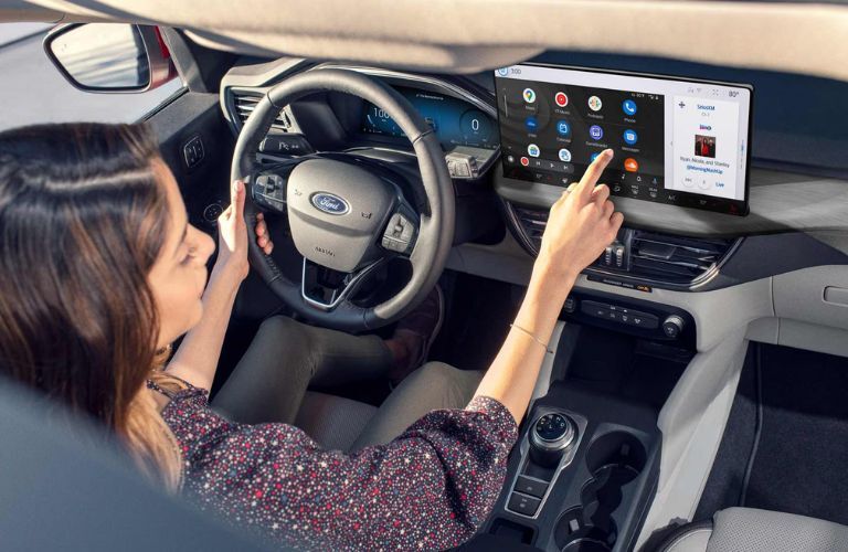 2025 Ford Escape ST-Line Elite with a driver using the touchscreen