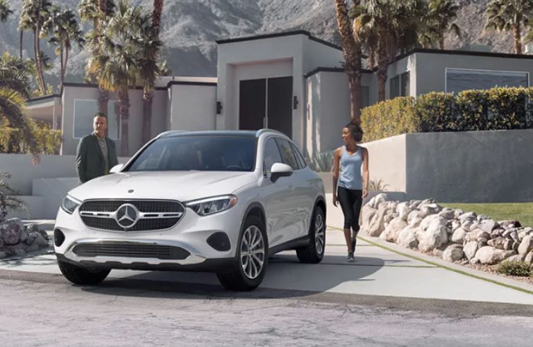 a man and woman walking towards the 2026 Mercedes-Benz GLC 300 4MATIC® SUV