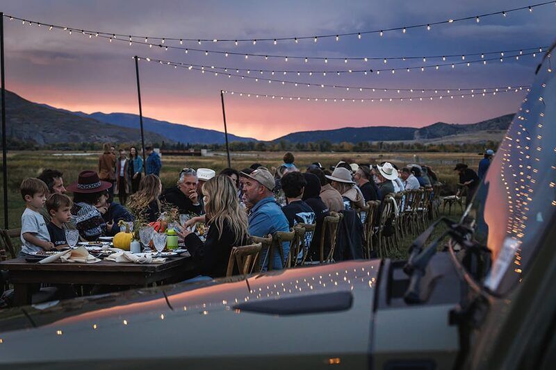 Outdoor community dinner under string lights at Bolt Ranch 2025