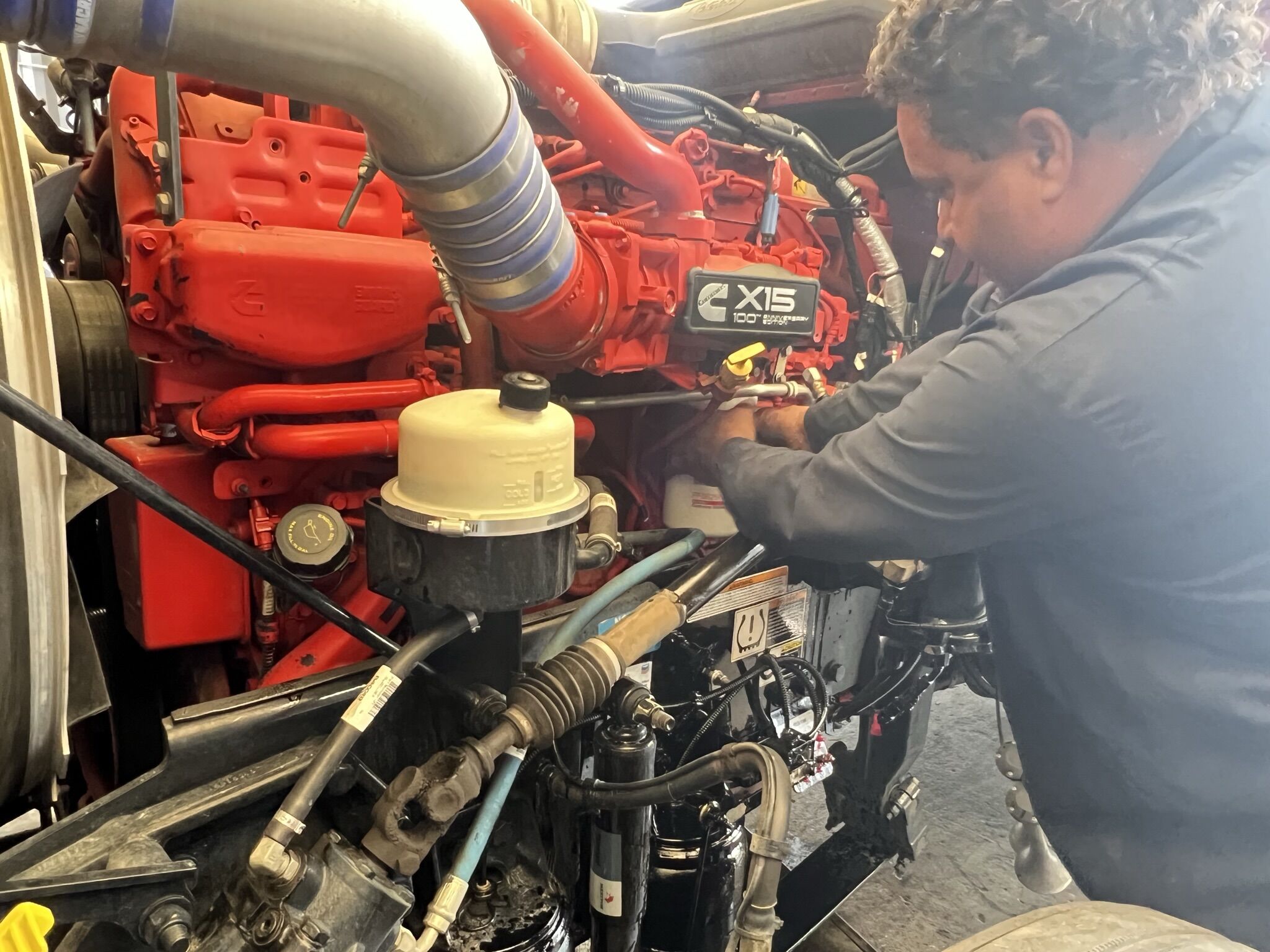 A mechanic working on the turbocharger for a diesel truck engine