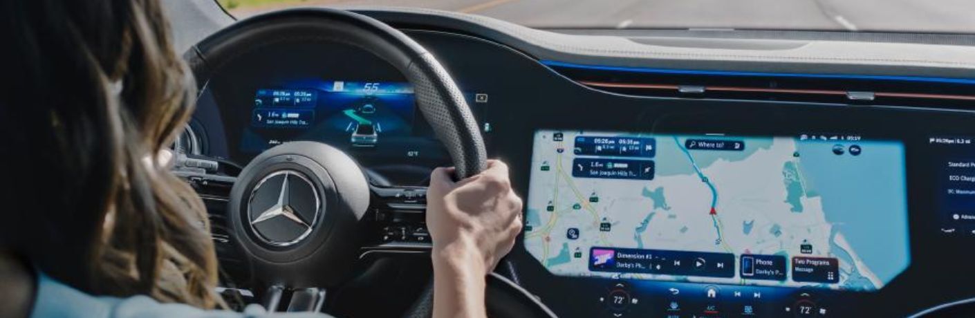 a woman driving a Mercedes-Benz while using the navigation system