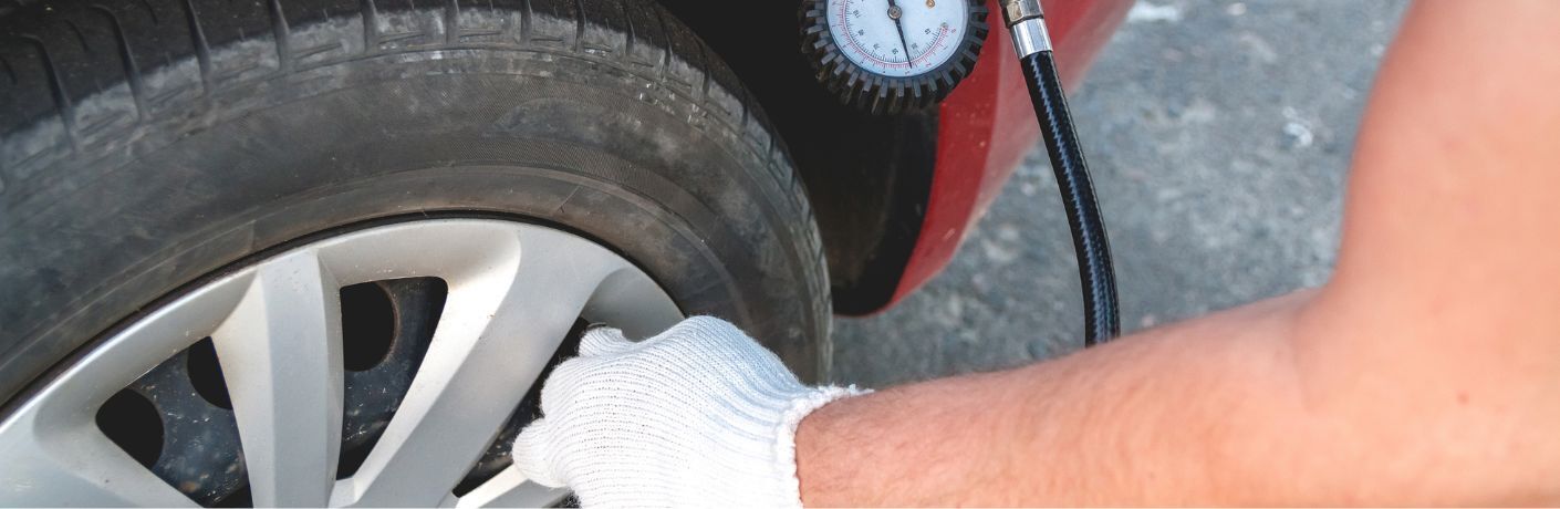 technician checking the tire pressure of a vehicle