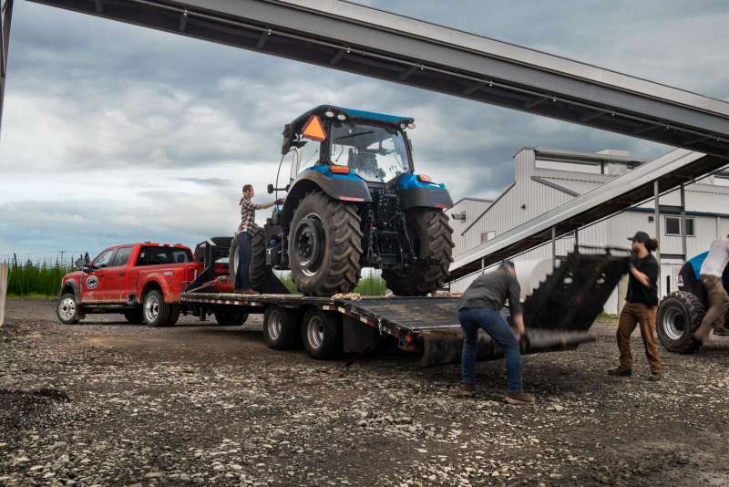 A front 3/4 view of the 2026 Ford F-450 towing a large flatbed trailer