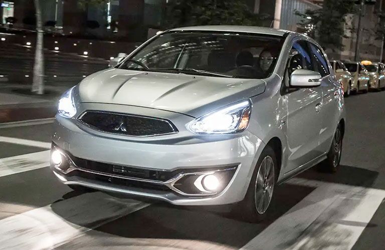 2020 Mitsubishi Mirage Gray paint driving on city highway with cityscape in background