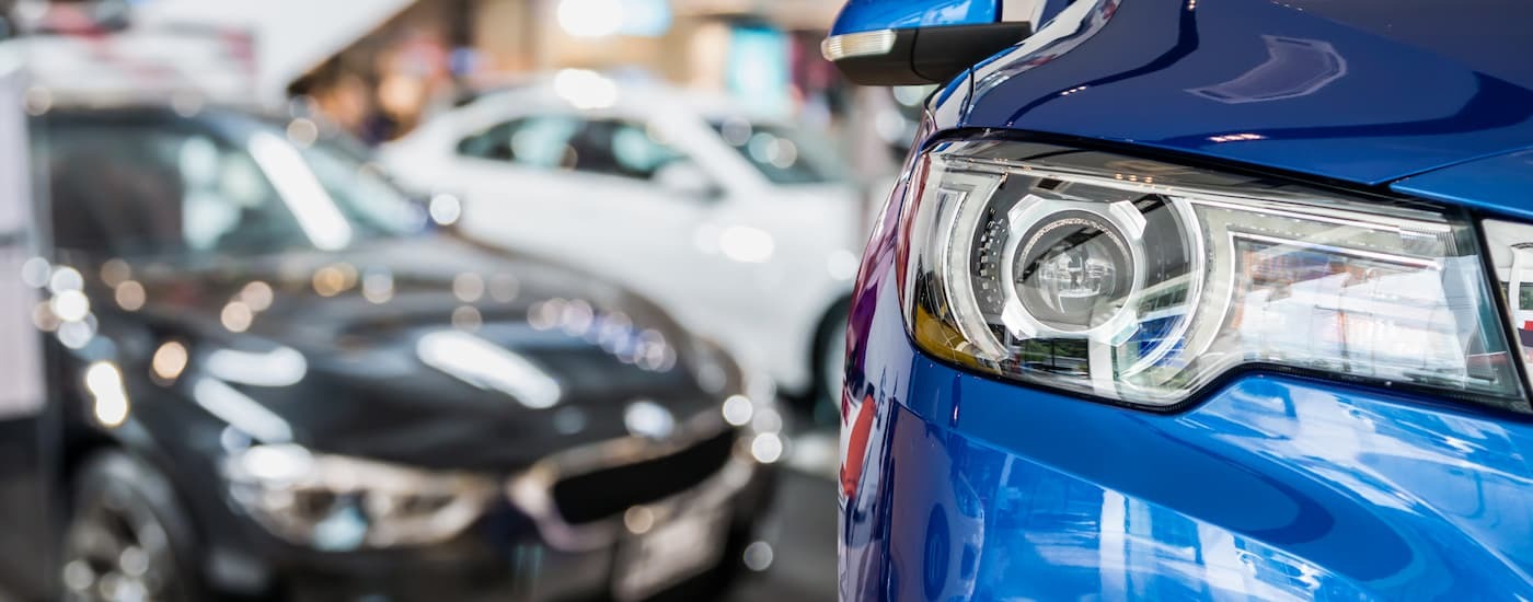A close up of the headlight on a blue car for sale near Elizabeth.