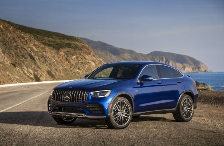 2020 MB AMG GLC Coupe exterior front cabin driver side on side of road with ocean and hill