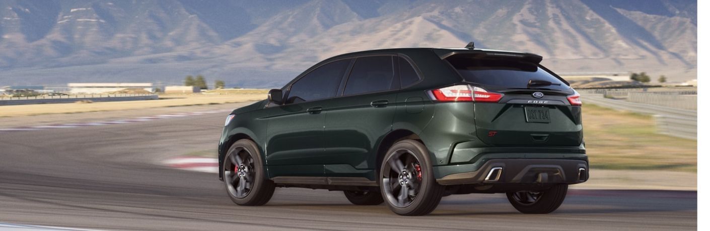 One green color 2022 Ford Edge is running on the road.