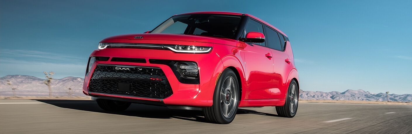 Exterior view of a red 2020 Kia Soul driving down a desert highway