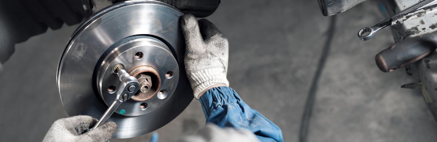 technician fixing a wheel in a car