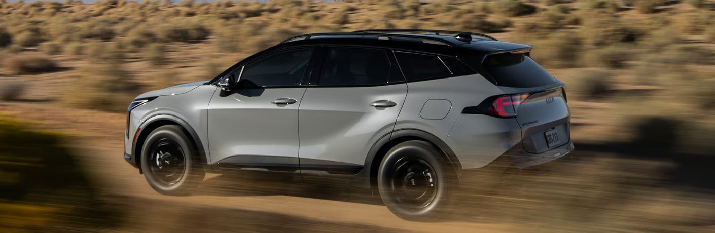 2026 Kia Sportage side view driving off-road