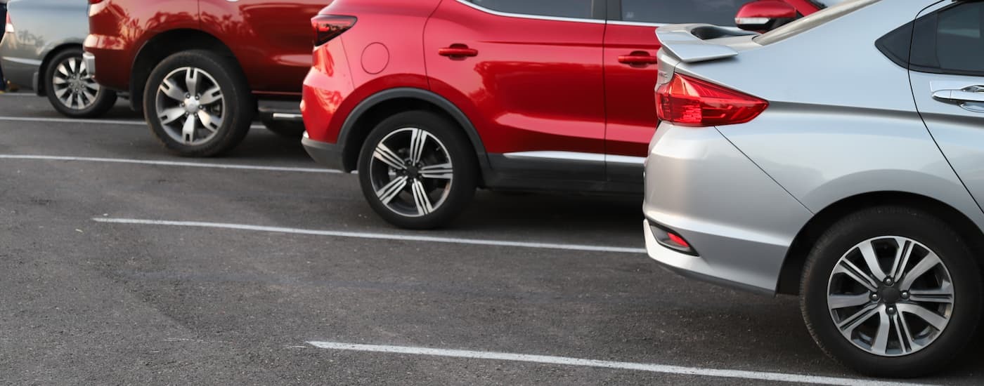 A row of used cars for sale near North Bergen are parked at a dealership parking lot.